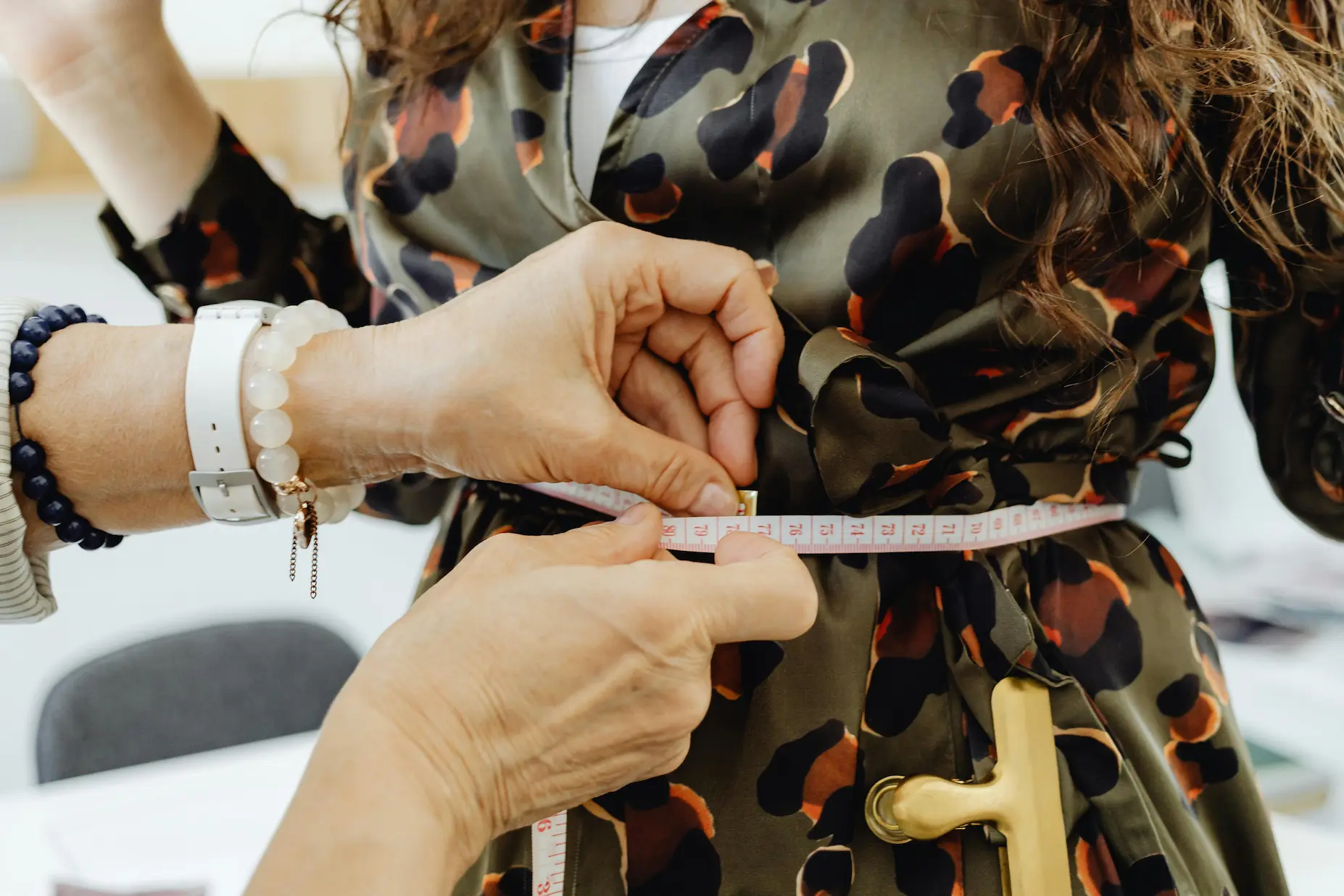 Croitor marcând ajustările pe o haină cu cretă de croitorie